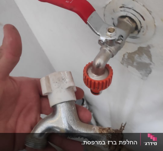 ברז מתכת מנותק עם ידית אדומה ותפוסה חלודה